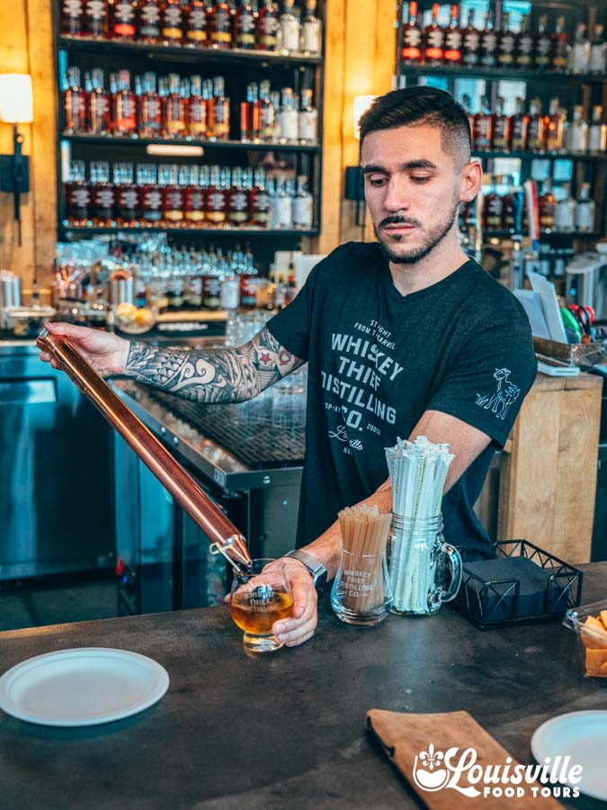 Whiskey Thief bartender pouring a thieved cocktail