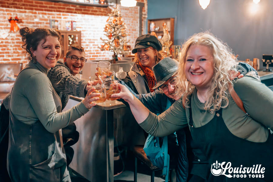 Bourbon drinkers doing a cheers in a speakeasy in Louisville Kentucky