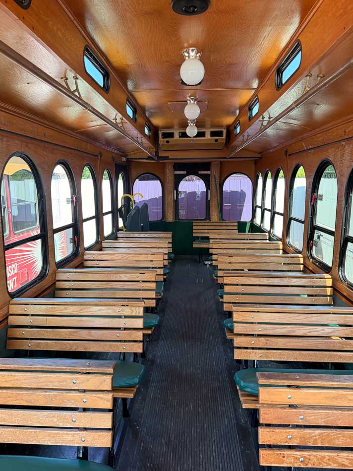 Old Fashioned Express Trolley interior bench seating with green pads and arched windows