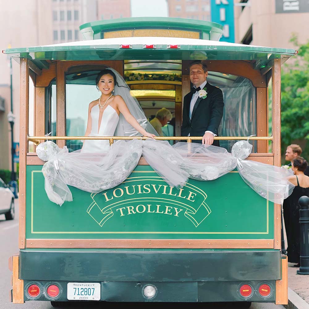 Bride and groom posing for a wedding photo on the Toonerville trolley in Louisville Kentucky